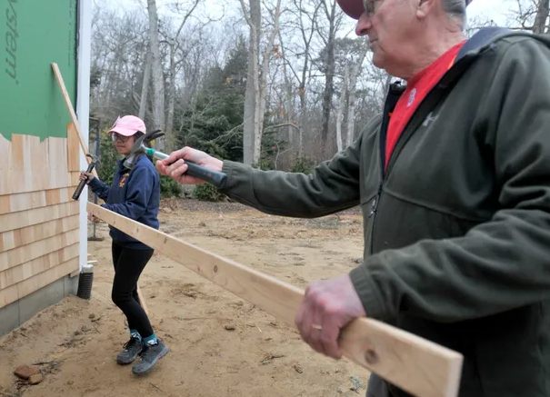 Cape Cod Times Images by Merrily Cassidy, Image of Volunteer Bob Lodi and Future Homeowner Bernalynn Sargent shingling at Phoebe Way