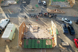 Aerial image of volunteers and future homeowners raising walls on a Habitat for Humanity of Cape Cod home on Old Kings Highway in Wellfleet.