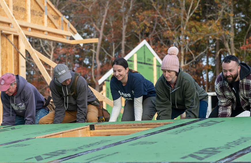 Image of volunteers and a future homeowner raising walls on a Habitat for Humanity of Cape Cod home on Old Kings Highway in Wellfleet.