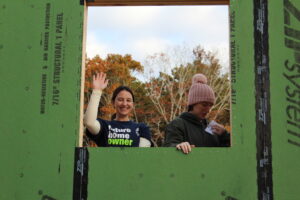 Image a future homeowners waiving out the kitchen window at Habitat for Humanity of Cape Cod's Wall Raising Ceremony on Old Kings Highway in Wellfleet.